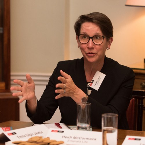 Portrait of Heidi McCormack in front of colorful paintings